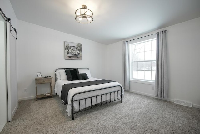 carpeted bedroom featuring lofted ceiling and a barn door