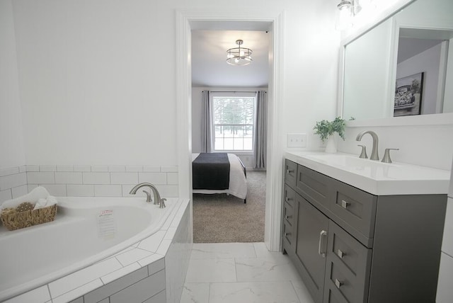 bathroom with tiled tub and vanity