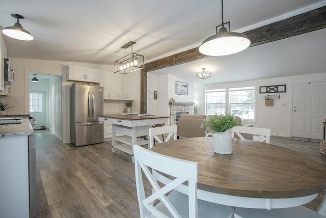 dining area featuring lofted ceiling with beams and hardwood / wood-style flooring