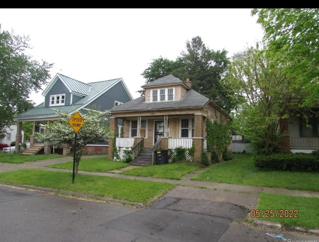 view of front of home with a porch and a front lawn