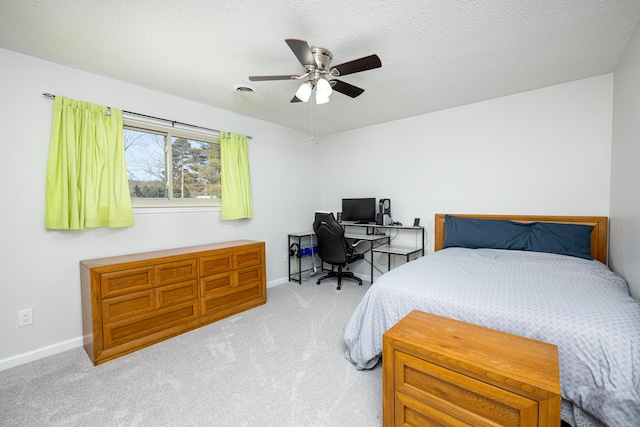 carpeted bedroom with ceiling fan and a textured ceiling