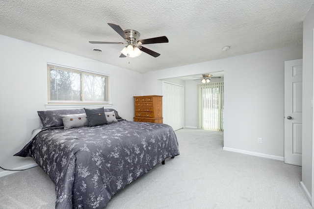 bedroom with light carpet, a textured ceiling, a closet, and ceiling fan