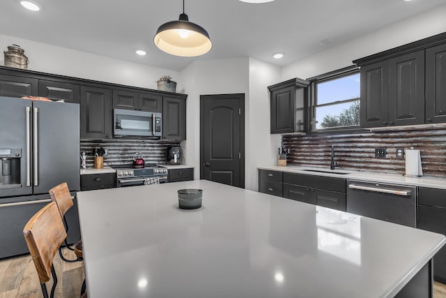 kitchen with sink, a center island, appliances with stainless steel finishes, pendant lighting, and decorative backsplash