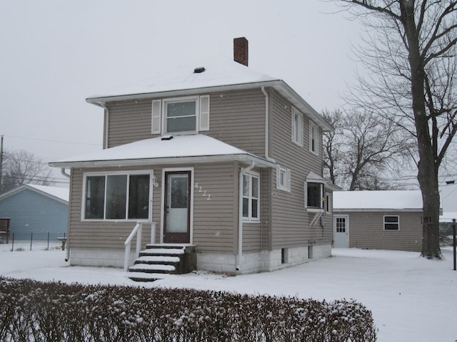 view of snow covered rear of property