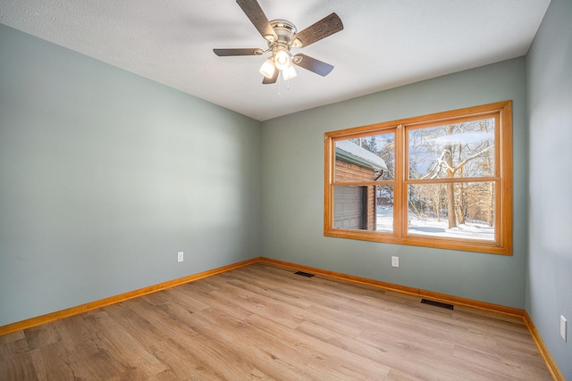 empty room featuring ceiling fan and light hardwood / wood-style floors