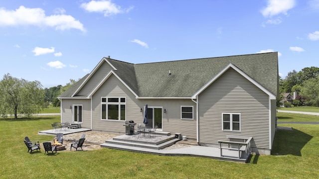 rear view of house with a patio, a lawn, and a fire pit