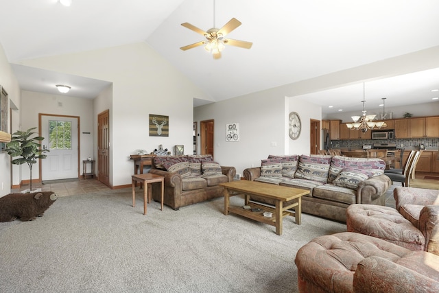 carpeted living room with high vaulted ceiling and ceiling fan with notable chandelier