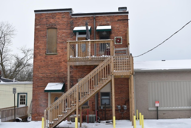 snow covered property with central air condition unit