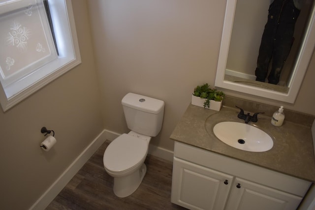 bathroom with toilet, vanity, and hardwood / wood-style floors