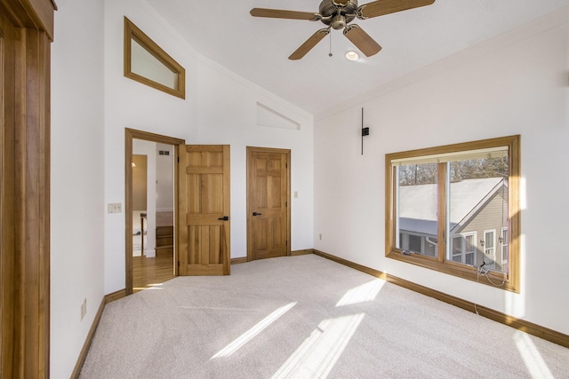 unfurnished bedroom with light carpet, ceiling fan, and high vaulted ceiling