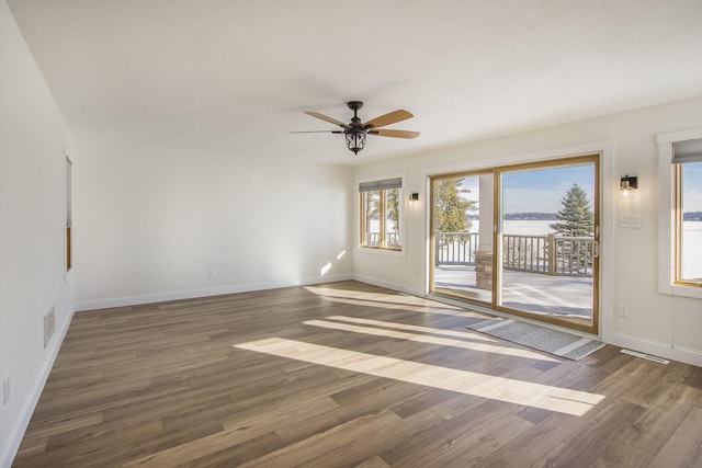 empty room with ceiling fan and dark hardwood / wood-style floors