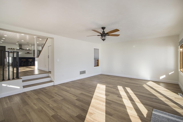 unfurnished living room with ceiling fan and wood-type flooring