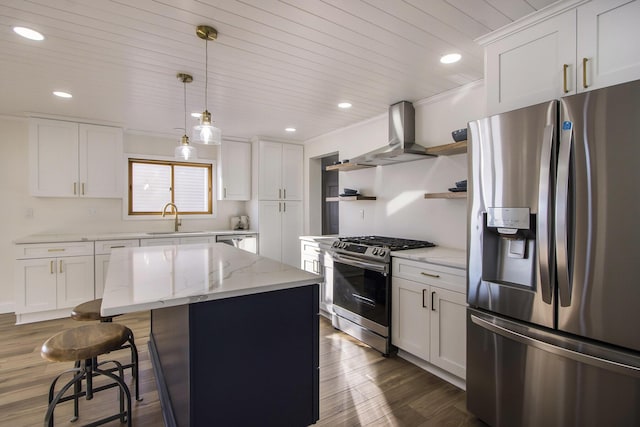 kitchen with white cabinetry, wall chimney range hood, appliances with stainless steel finishes, and a center island