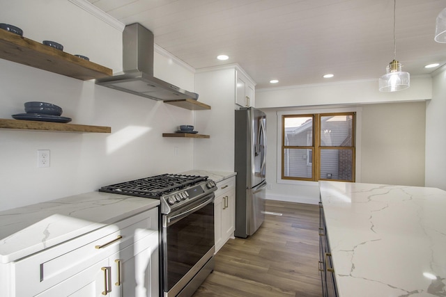 kitchen with white cabinetry, stainless steel appliances, hanging light fixtures, wall chimney exhaust hood, and light stone counters