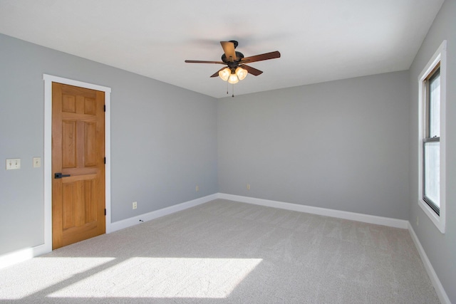 carpeted empty room featuring ceiling fan and a wealth of natural light