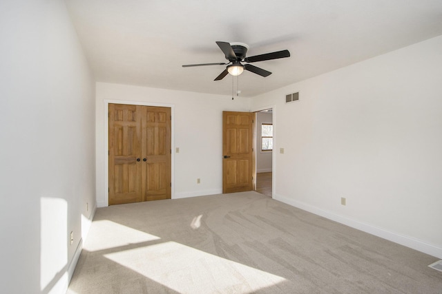 unfurnished bedroom featuring ceiling fan, carpet, and a closet