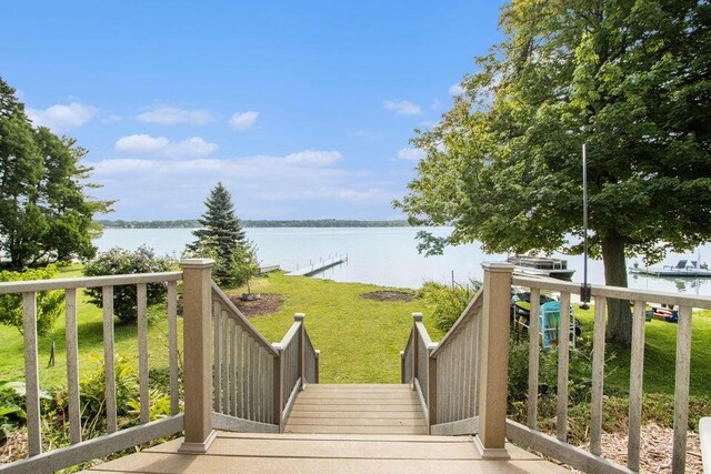 wooden deck with a water view and a yard