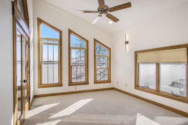 carpeted spare room featuring ceiling fan