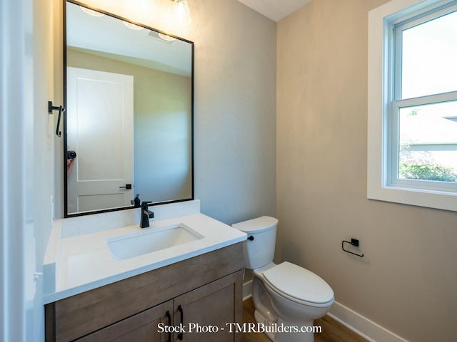 bathroom with toilet, wood-type flooring, and vanity