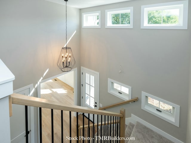 staircase featuring carpet floors and a notable chandelier