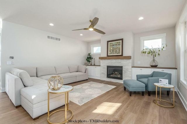 living room with ceiling fan, light hardwood / wood-style floors, and plenty of natural light