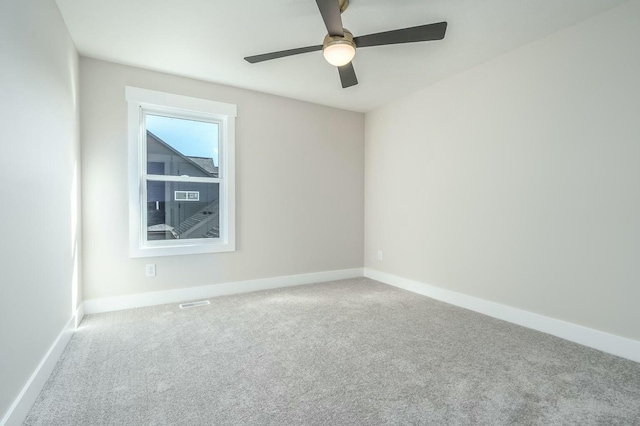 carpeted spare room featuring ceiling fan