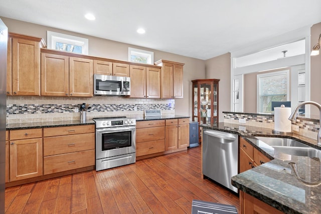 kitchen featuring decorative backsplash, sink, hardwood / wood-style floors, and appliances with stainless steel finishes