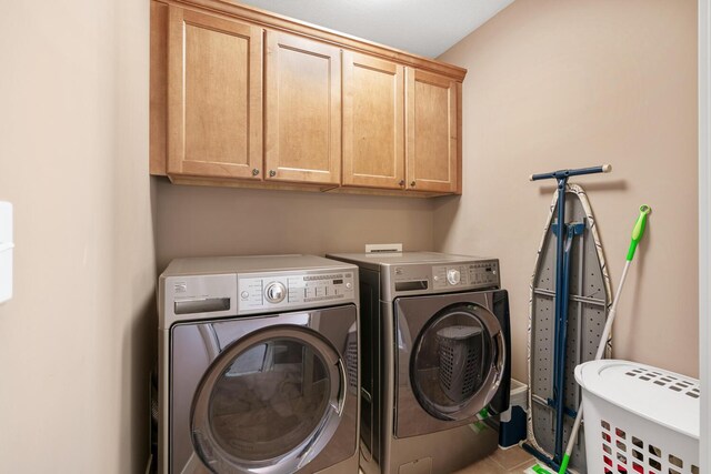 laundry room with washer and clothes dryer and cabinets