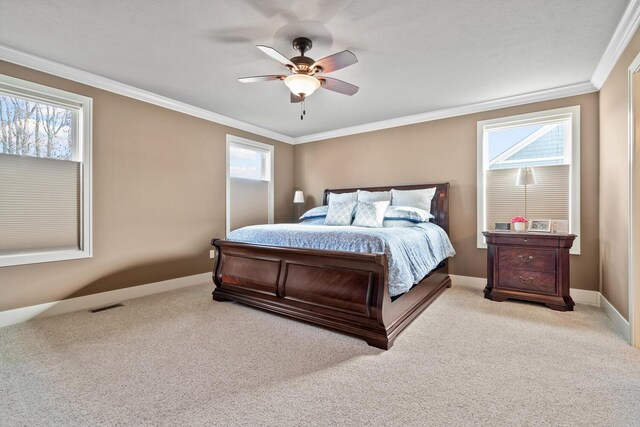 carpeted bedroom with ceiling fan, multiple windows, and crown molding