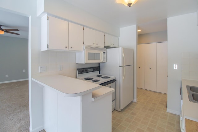 kitchen with kitchen peninsula, ceiling fan, white cabinets, and white appliances