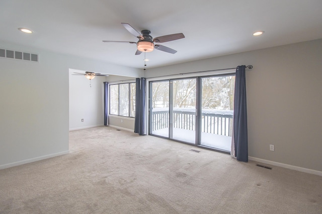 carpeted spare room featuring ceiling fan