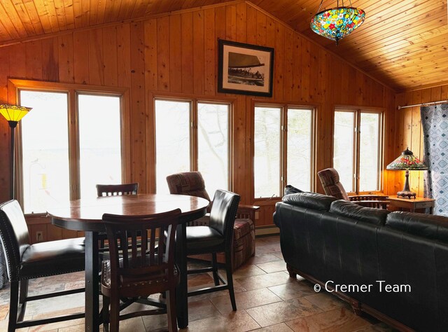 dining area with a baseboard heating unit, lofted ceiling, and wood ceiling