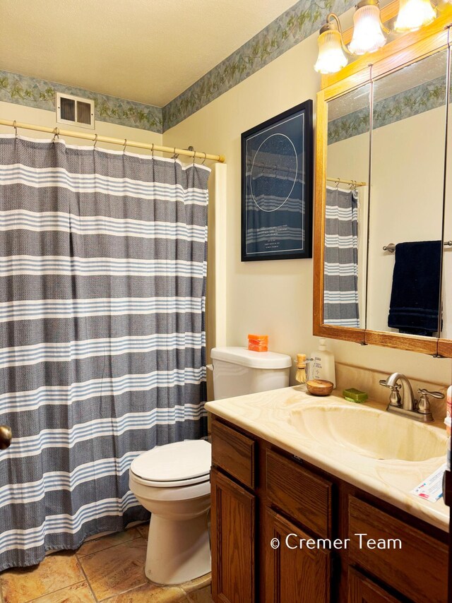 bathroom featuring vanity, toilet, and tile patterned flooring