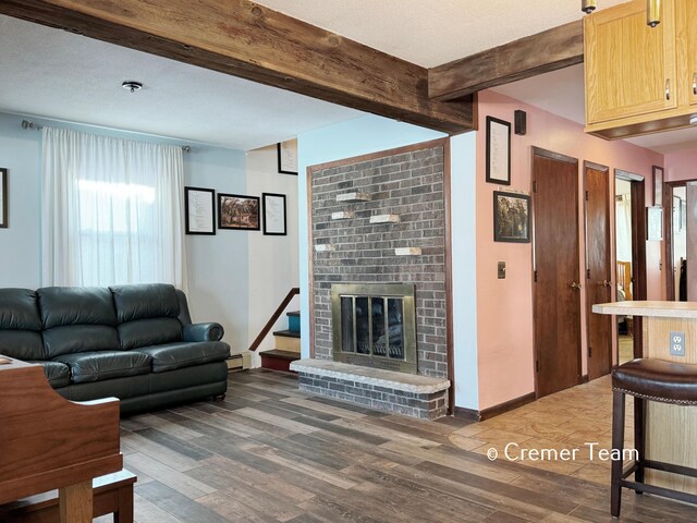 living room featuring dark wood-type flooring, beam ceiling, and a fireplace