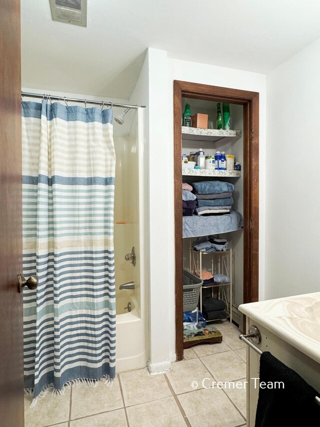 bathroom with vanity, shower / bathtub combination with curtain, and tile patterned flooring