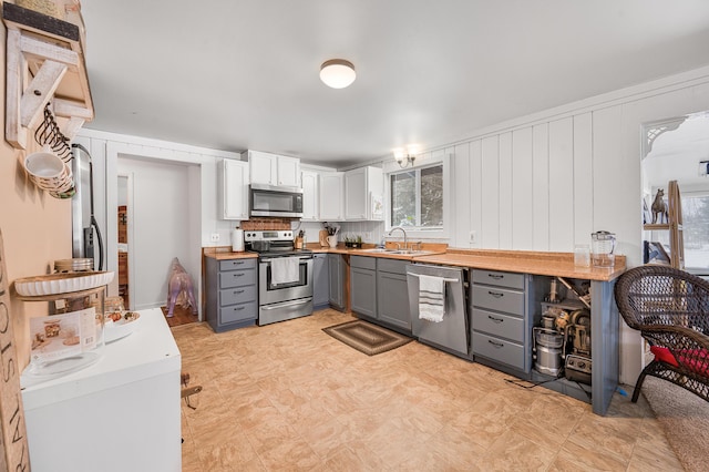 kitchen featuring stainless steel appliances, sink, white cabinets, and gray cabinets