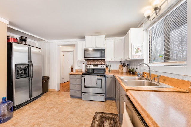 kitchen with sink, white cabinetry, gray cabinets, and stainless steel appliances