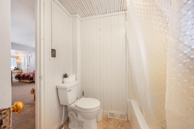 bathroom with toilet and a tub to relax in