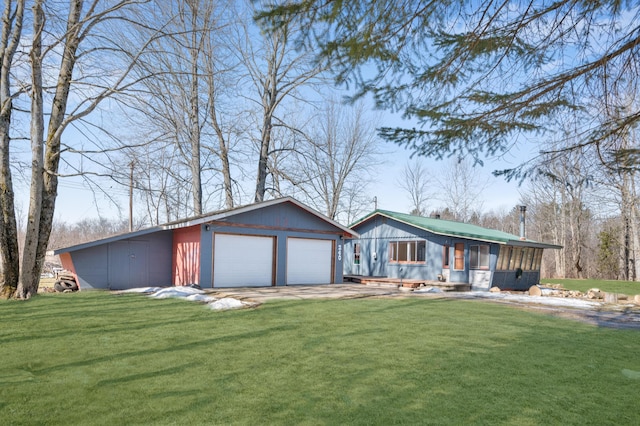 view of front of house featuring a garage, an outdoor structure, and a front lawn