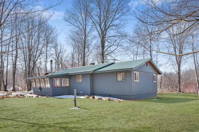 view of side of home with crawl space, metal roof, a lawn, and a chimney