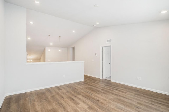 unfurnished room with hardwood / wood-style flooring and lofted ceiling