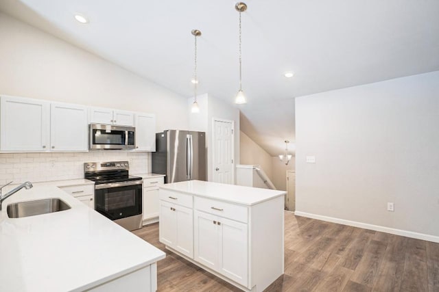 kitchen featuring pendant lighting, sink, stainless steel appliances, a center island, and white cabinets