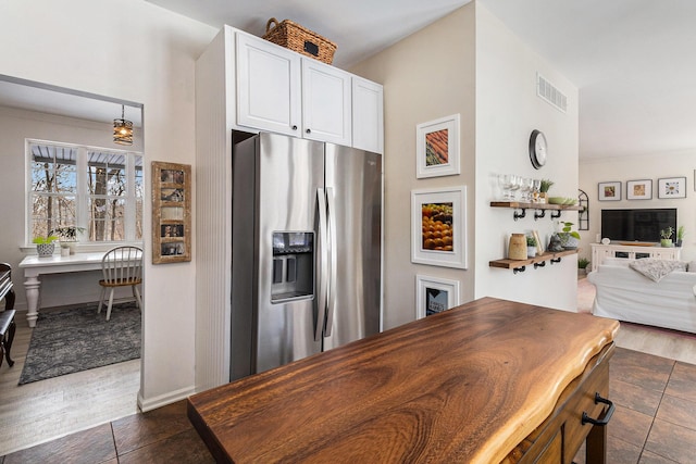 kitchen featuring stainless steel refrigerator with ice dispenser, white cabinetry, and decorative light fixtures