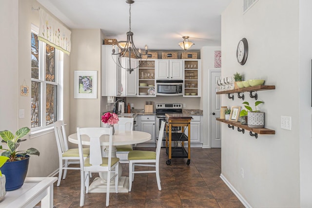 dining space with a wealth of natural light, a chandelier, and sink