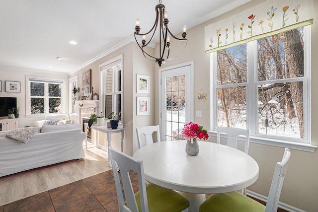 dining room with an inviting chandelier, ornamental molding, and a healthy amount of sunlight