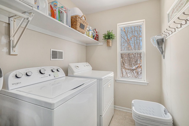 laundry area featuring light tile patterned floors and separate washer and dryer