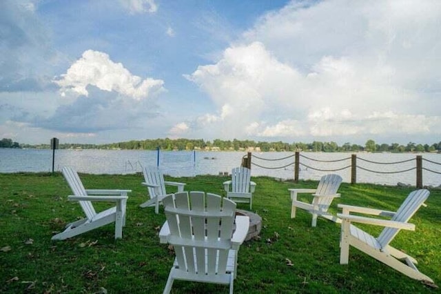 view of property's community with a water view and a lawn