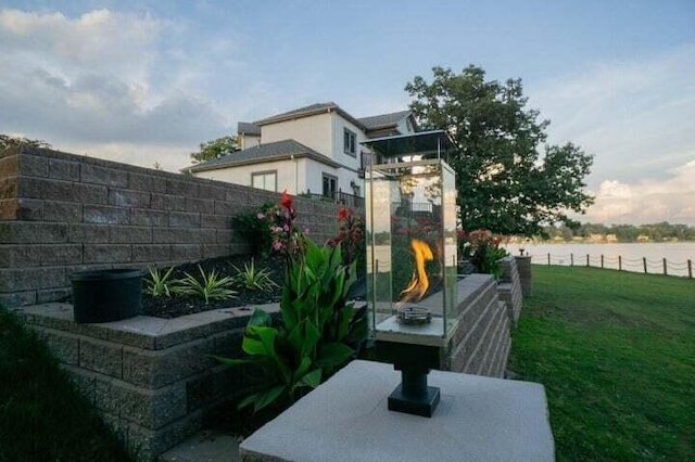 view of yard featuring a water view and a fireplace