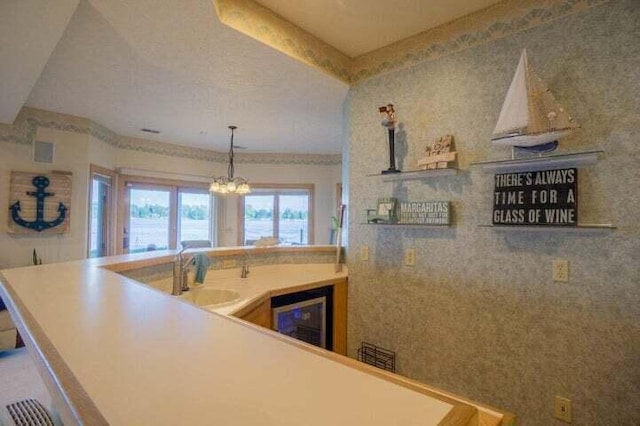 kitchen featuring an inviting chandelier, wine cooler, and sink