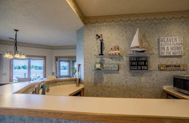 kitchen with sink, a chandelier, and pendant lighting